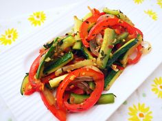 a white plate topped with veggies on top of a flowered table cloth