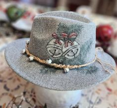 Felt/poly heathered hat hand burned with Christmas sleigh bells and evergreen pattern. Hand colored and hand beaded and braided jingle bell band. Adjustable and nice quality ... fun for any event, Christmas parties, awesome Christmas gift! Handmade Fedora With Short Brim As Gift, Artisan Adjustable Felt Hat For Winter, Adjustable Artisan Fedora For Winter, Artisan Adjustable Fedora For Winter, Handmade Short Brim Fedora As Gift, Artisan Hats For Winter Country Events, Handmade Fedora With Curved Brim For Winter, Adjustable Brimmed Hat For Holiday, Adjustable Hat With Curved Brim For Holidays