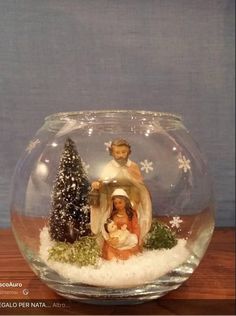 a nativity scene in a glass bowl with snow