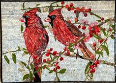 two red birds sitting on top of a tree filled with leaves and berries next to each other