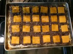 an easy cookie sheet slider with cheese squares on it in the oven, ready to go into the oven