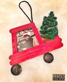 a small red toy truck with a christmas tree on it's back and a photo frame attached to the front