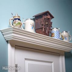 there are many mugs on top of the mantle in this room with blue walls