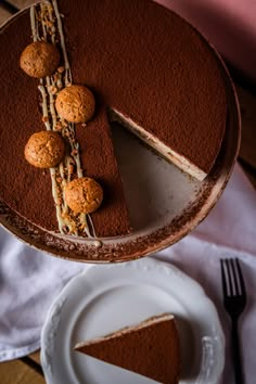 a piece of chocolate cake on a plate with a slice cut out and ready to be eaten