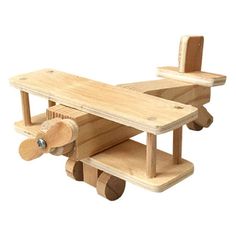 a wooden toy airplane sitting on top of a white surface with wheels attached to it