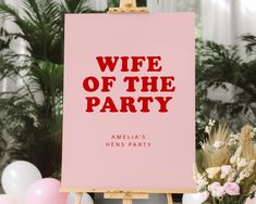 a pink sign with the words wife of the party on it next to some flowers and balloons