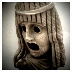 a statue of a woman wearing a headdress with her eyes closed and mouth wide open