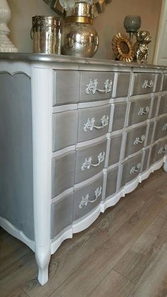 a white dresser with many drawers and silver knobs