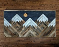 a wood panel with mountains painted on it and a moon in the sky above them