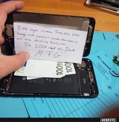 someone is opening up their cell phone with a note attached to the front cover and side panel