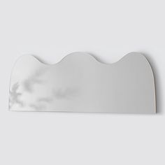 a mirror that is on the wall with clouds in the sky and water behind it