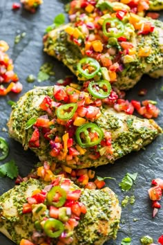 several pieces of chicken covered in salsa and garnished with cilantro peppers