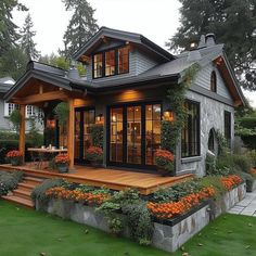 a house with lots of windows and flowers in the front yard