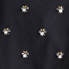 several small white and gold studs on a black jacket