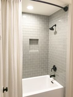 a white bath tub sitting next to a shower