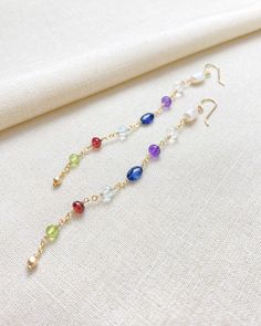 Elevate your next special occasion with a touch of understated luxury. Our delicate linear gemstone earrings showcase a stunning mix of semiprecious gemstones and freshwater pearls, radiating elegance and charm with every move. The 14k gold-filled ear wires are smooth and comfortable and will arrive with clear ear backs for a secure fit. Length: 4 inches from top of the ear wire Materials: 14K gold-fill, cultured freshwater pearls, crystal quartz, amethyst, kyanite, aquamarine, garnet, peridot G Luxury Gemstone Linear Earrings As Gift, Luxury Gemstone Linear Earrings, Elegant Multi-stone Briolette Earrings, Elegant Multicolor Pearl Drop Earrings, Elegant Multicolor Drop Bridal Earrings, Fine Jewelry Gemstone Linear Earrings As Gift, Fine Jewelry Linear Gemstone Earrings, Elegant Dangle Linear Earrings With Gemstones, Elegant Linear Drop Earrings With Natural Stones