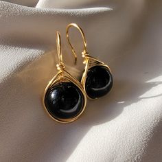 Immerse yourself in spectacular luxury with our Large Black Pearl Earrings in a drop design. These magnificent jewels fuse the timeless elegance of pearls with a touch of contemporary boldness, offering a stunning visual impact. Each majestically selected black pearl hangs gracefully in a generous drop design, providing unmatched visual appeal. The fullness of these black pearls adds a touch of drama and sophistication to your style, turning your every move into a fashion statement. The meticulously crafted setting, available in gold fill enhances the natural beauty of the pearls and adds a touch of opulence to these earrings. These jewels are not only accessories, but masterpieces that will transform any occasion into an elegant event. Whether for a special evening or to elevate your ever Luxury Black Pearl Earrings For Anniversary, Black Pearl Jewelry Design, Elegant Hypoallergenic Party Earrings, Elegant Hypoallergenic Earrings For Party, Hypoallergenic Round Pearl Earrings For Party, Wire Wrapped Round Jewelry For Parties, Elegant Round Wire Wrapped Jewelry, Wire Wrapped Jewelry For Parties, Elegant Drop Crystal Earrings For Gift