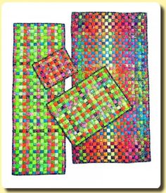 three pieces of colorful cloth with squares on the bottom and one piece in the middle