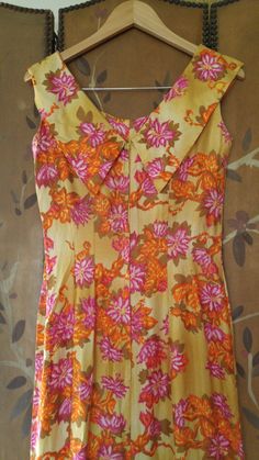 "Gorgeous 70s maxi Hawaiian dress in yellow ochre colour with orange and pink and mustard coloured flower print. The dress is long maxi length with fishtail hem which opens up in the middle between hem curtain. Fitted waist and bust. Collar goes around and over shoulders and ends at the back in two pointed 'collars. Zip up at back. Made by Liberty House, made in Hawaii, Kailua, Downtown Waialae By Hawaiian Casuals arm hole to arm hole 17\" (bust 34) waist 28\", hips 34\", dress length 55\"" Retro Floral Print Floor-length Maxi Dress, Vintage Orange Floral Print Dress, Yellow Retro Maxi Dress, Retro Fitted Orange Maxi Dress, Vintage Yellow Floral Print Dress, Yellow Retro Maxi Dress For Spring, Retro Yellow Maxi Dress For Spring, Vintage Yellow Floor-length Dress, Retro Yellow Maxi Dress