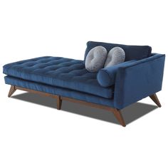 a blue velvet chaise lounge with two pillows on it's back and legs