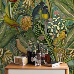 a tropical wallpaper with birds, flowers and pineapples is featured in this room