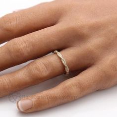 a woman's hand with a wedding ring on top of her left hand,