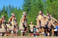 a group of people standing on top of a stage next to each other in native clothing