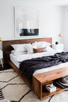 a bed with white sheets and pillows in a bedroom