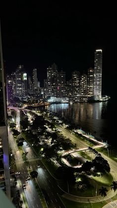 an aerial view of a city at night from a high rise building in the foreground