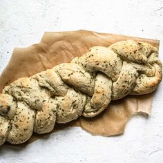 a piece of bread that has been braided into it on top of wax paper