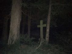 a cross in the woods at night with no one around it or on the ground