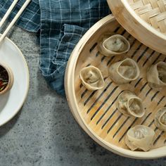 an overhead view of some dumplings with sauce and chopsticks