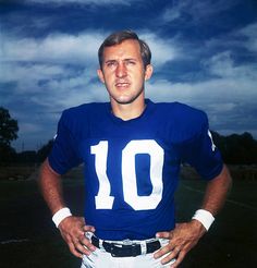 a man in a football uniform is standing with his hands on his hips and looking at the camera