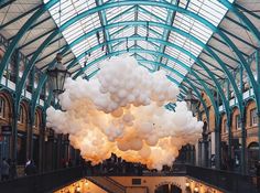 an indoor atrium with large white balloons hanging from the ceiling