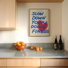 a bowl of oranges sitting on top of a kitchen counter