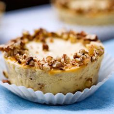 there is a cupcake with nuts on it sitting on a blue table cloth next to other desserts