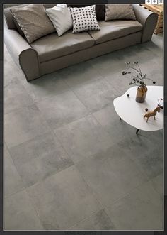 a living room with grey tile flooring and furniture