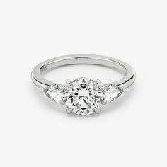 an engagement ring with three stones on the side and a round brilliant diamond center stone