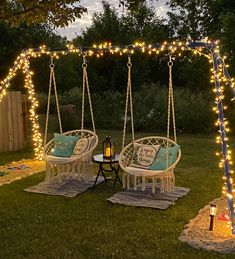 two chairs and a table are set up in the yard with lights strung across them