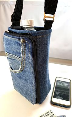 a cell phone is in the pocket of a blue jean bag with a camera attached to it