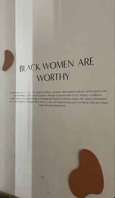 an advertisement for black women are worthy on the side of a white wall with brown shapes