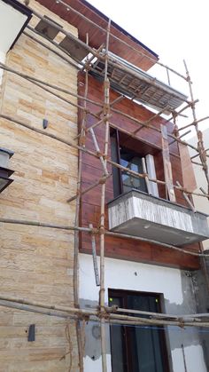 a building with scaffolding on the side of it that is being constructed to look like wood