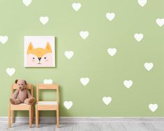 a teddy bear sitting on a chair in front of a wall with hearts