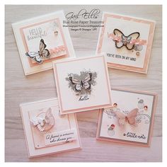 four cards with butterflies on them sitting on top of a wooden table next to each other