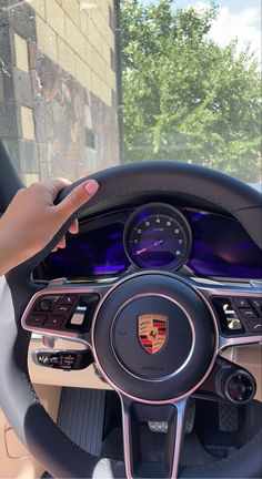 a woman driving a car with her hand on the steering wheel while holding onto the dashboard