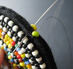 a close up of a person's hand holding a beaded object