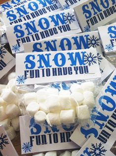 there are many snow themed candy bags on the table with white marshmallows