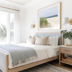 a bedroom with a bed, nightstands and large window overlooking the beach in front of it