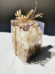 a clear box filled with white candles on top of a table