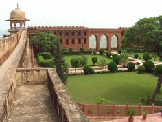 an old building with a large garden in the foreground and a stone walkway leading up to it